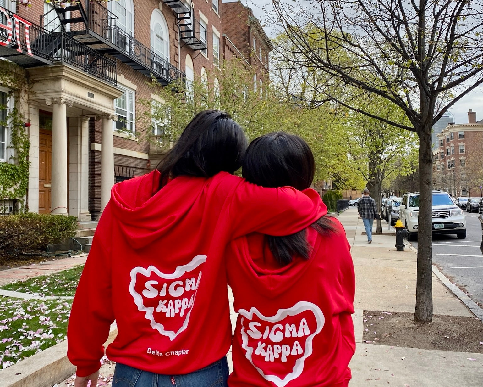 Two Sigma Kappa girls from sorority wearing custom hoodie are hugging each other